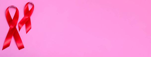 ピンクの背景に赤いリボンのコンセプトでトップビュー12月1日国際エイズデーのクローズアップ。バナー - 写真・画像