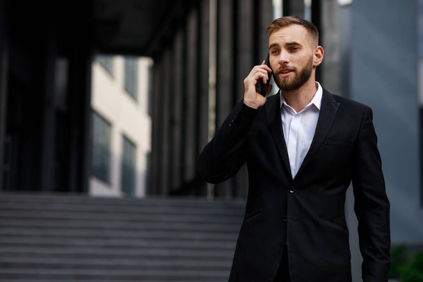 портрет молодого бизнесмена, разговаривающего по телефону - Фото, изображение