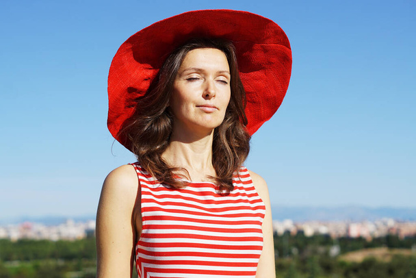 A Spanish woman wearing a red hat and posing - Фото, зображення