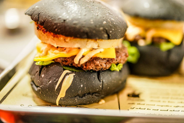 Black burger with delicious patties and cheese - Foto, Imagem