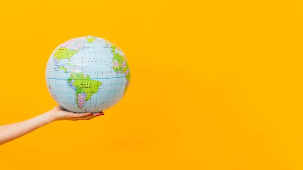 side view hand holding earth globe with copy space. High quality photo - 写真・画像