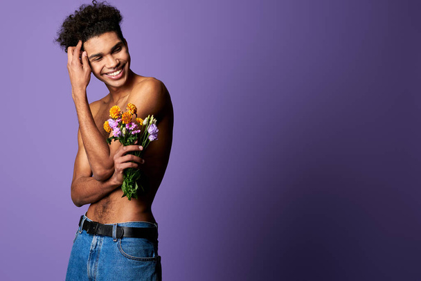 Portrét usměvavého transsexuálního muže s květinami. Citlivý atletický sportovec s dokonalým tělem - Fotografie, Obrázek