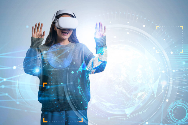Businesswoman in green sweater is wearing vr helmet. Digital interface with geometrical figures and line connection in the foreground. Concept of virtual reality. This image is furnished by NASA. - Fotografie, Obrázek