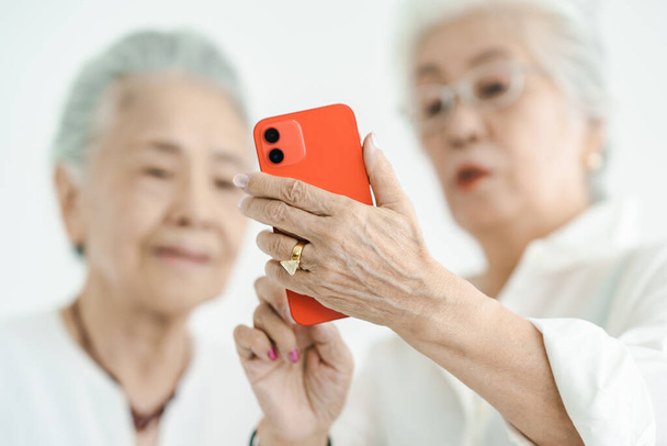 Seniorinnen bedienen Smartphone durch Versuch und Irrtum - Foto, Bild