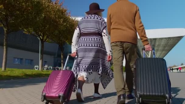 Senior manžel manželka důchodci turisté jít na letiště terminál pro stravování se zavazadly na kolech - Záběry, video