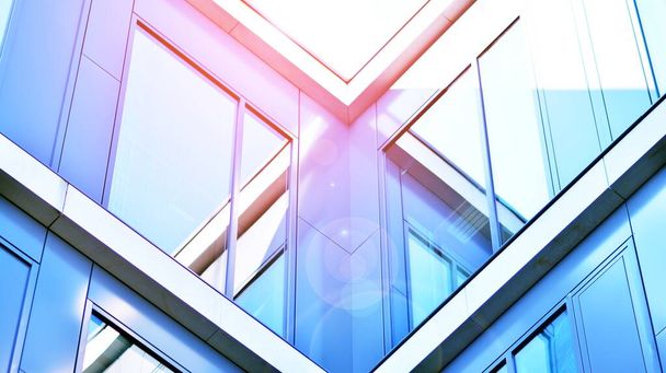 Modern kantoorgebouw met glazen gevel op een heldere hemelse achtergrond. Transparante glazen wand van kantoorgebouw. - Foto, afbeelding