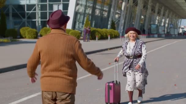 Ancianos marido viejo esposa jubilados turistas reunión en la terminal del aeropuerto después de larga separación - Imágenes, Vídeo