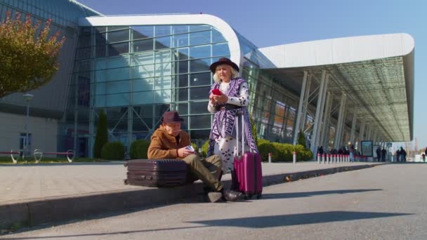 Nudí senioři manžel a manželka v důchodu turisté čekají na zpožděný nástup na letiště terminálu - Záběry, video