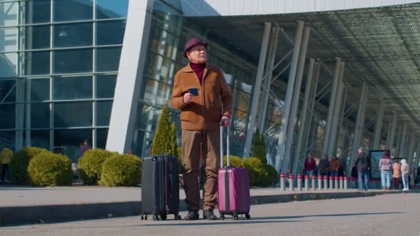 Portret starszego emeryta turysty w pobliżu terminalu lotniskowego czekającego na wejście na pokład samolotu do podróży - Materiał filmowy, wideo