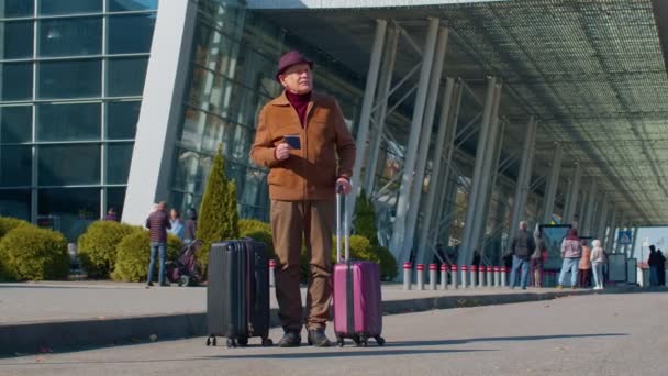 Starszy emerytowany człowiek turysta w pobliżu terminalu lotniska świętując sukces, zwycięstwa i cel osiągnięć - Materiał filmowy, wideo
