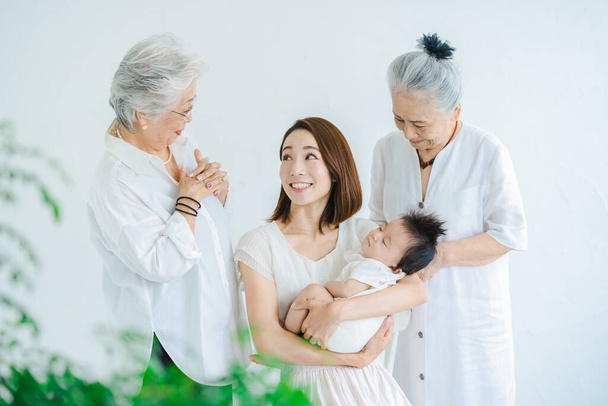 Aasialainen äiti tilalla vauva ja kaksi vanhempaa naista - Valokuva, kuva