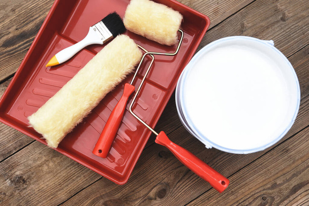 Painted tool with roller paint brush paint bucket canned paint for painting on wooden background, top view on paint tray - Photo, Image