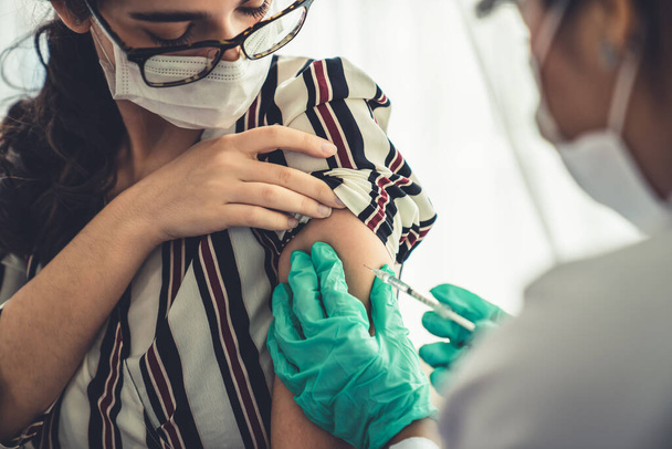 Młoda kobieta odwiedza zręcznego lekarza w szpitalu w celu szczepienia - Zdjęcie, obraz