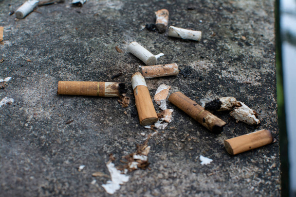 Leftover cigarette butts by the dirty pavement. - Foto, Imagem