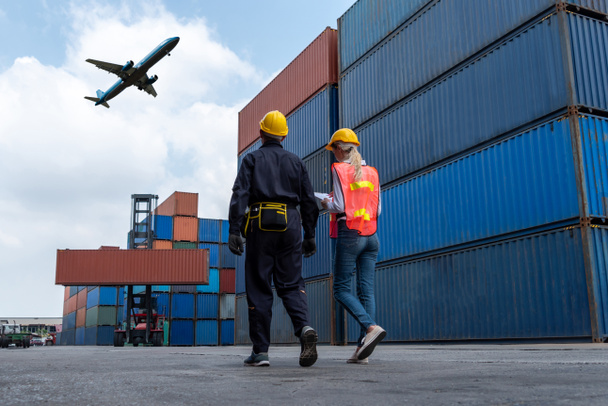 Trabajador industrial trabaja con su compañero de trabajo en el puerto de contenedores de envío en el extranjero - Foto, Imagen