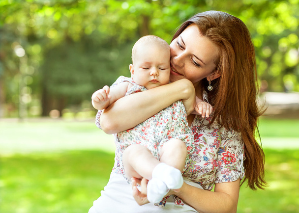 Portrait of happy loving mother and her baby outdoors - Фото, изображение