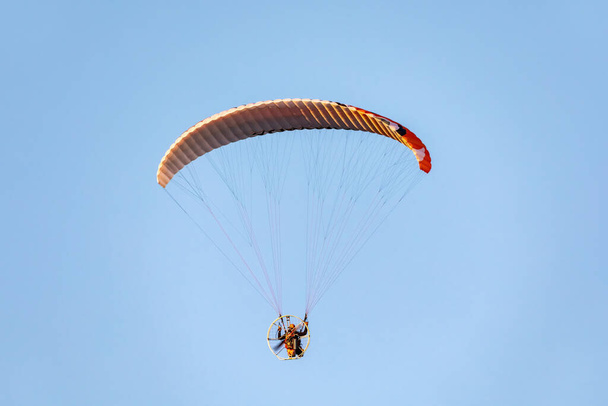 Aangedreven paragliding vlucht tegen de blauwe lucht. - Foto, afbeelding