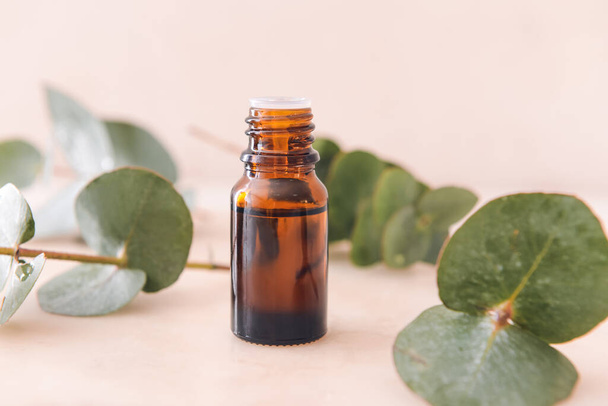 Bottle of eucalyptus essential oil on light background - Φωτογραφία, εικόνα