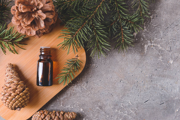 Bottle of coniferous essential oil on grunge background - Photo, Image