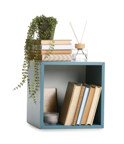 Маленький синий книжный шкаф с декором на белом фоне - Фото, изображение