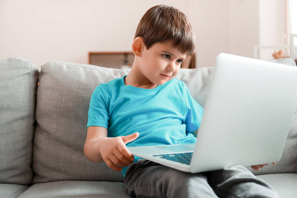 家でノートパソコンで漫画を見ている男の子 - 写真・画像