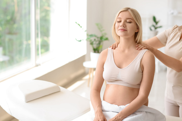 młoda kobieta w ciąży mając masaż w salonie spa - Zdjęcie, obraz