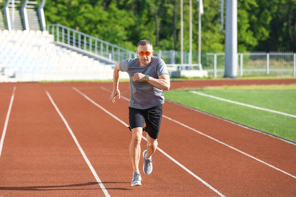 Sportlich reifer Mann läuft im Stadion - Foto, Bild