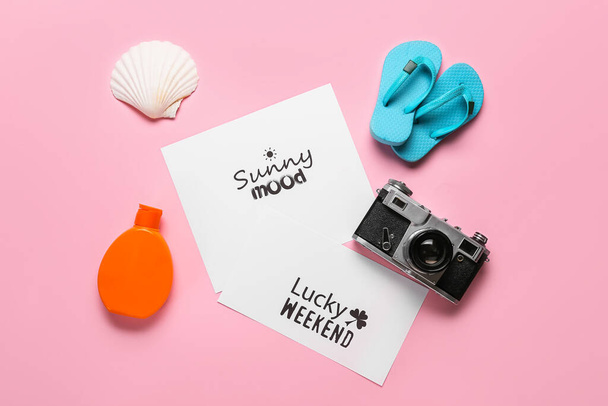 Paper sheets with motivations, photo camera, flip-flops and sunscreen cream on color background. New year goals - Photo, Image