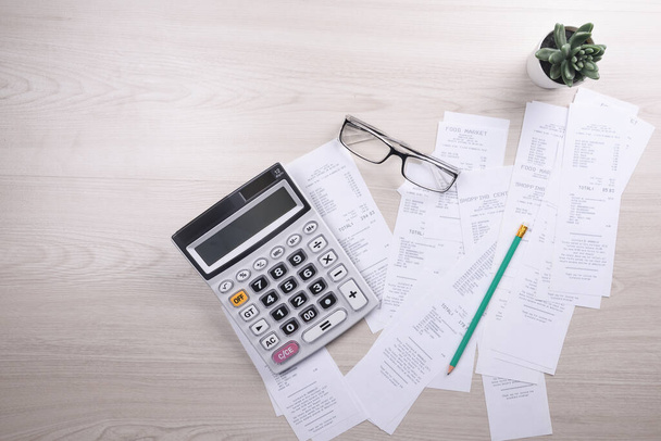 Unrecognizable businessman using calculator on desk office and writing make note with calculate about cost at home office. finance accounting concept. tax , shopping, cost management. - Photo, Image