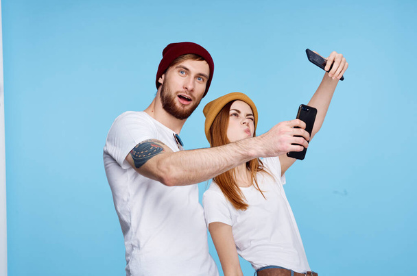 young couple killed in t-shirts with phones in their hands Modern technology - Photo, Image