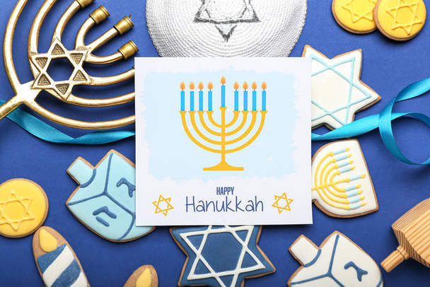 Different symbols of Hanukkah and greeting card on color background - Photo, Image