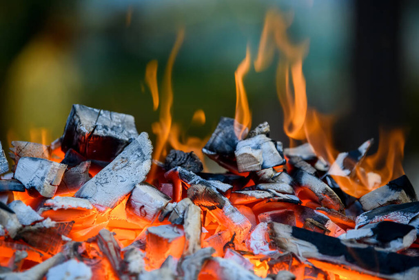 Lähikuva grilli kuoppa hehkuva ja liekehtivä kuuma hiili briketit  - Valokuva, kuva