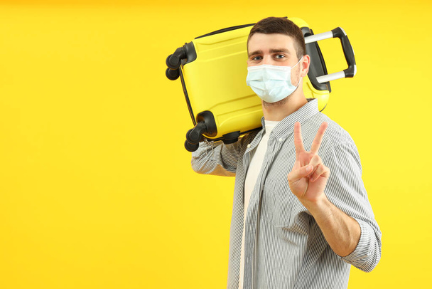 Traveling concept during coronavirus with young man on yellow background. - Foto, immagini