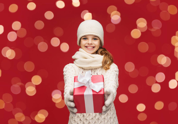 smiling girl in winter clothes with christmas gift - Фото, изображение