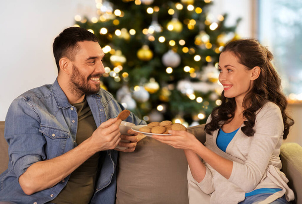 happy couple with cookies on christmas at home - 写真・画像