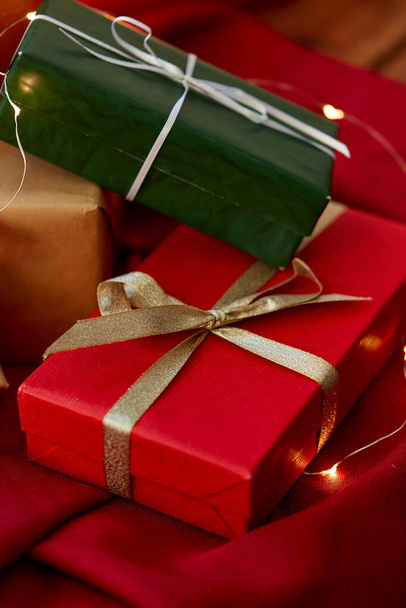 christmas gifts with garland on red tablecloth - 写真・画像