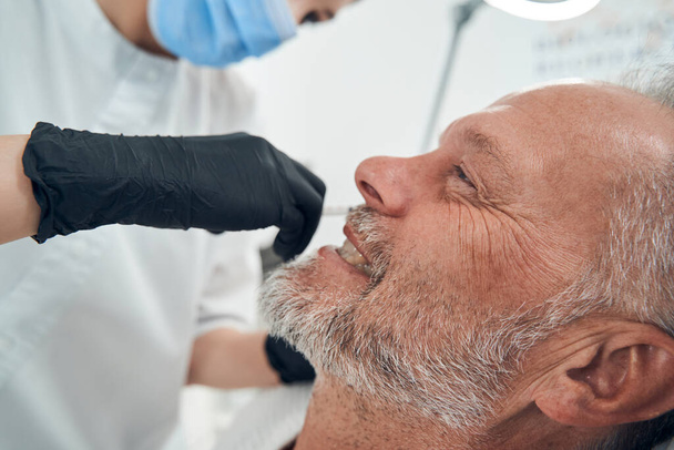 Homem alegre tendo procedimento de cuidados com a pele na clínica de cosmetologia - Foto, Imagem