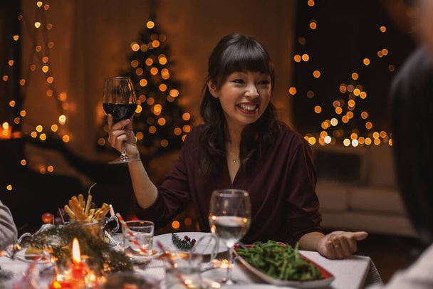 happy woman drinking red wine at christmas party - Foto, Bild