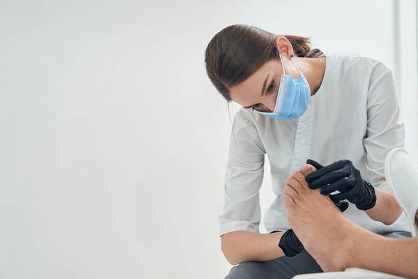 Žena kosmetička vyšetřující mužské prsty na kosmetické klinice - Fotografie, Obrázek