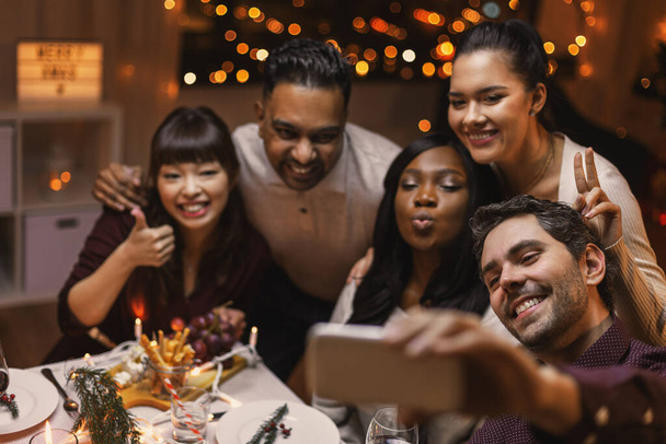 friends taking selfie on christmas dinner at home - Photo, image