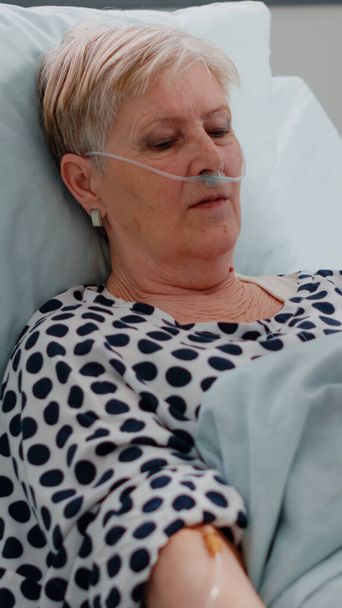 Femme malade en attente d'un traitement médical au lit - Photo, image