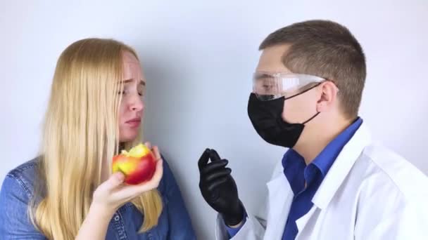 Pacient si stěžuje lékaři na ztrátu vkusu. Dívka na recepci terapeuta zkouší jídlo a zdravotník analyzuje test. Příznaky Covid19. Ochranná maska, brýle a rukavice - Záběry, video