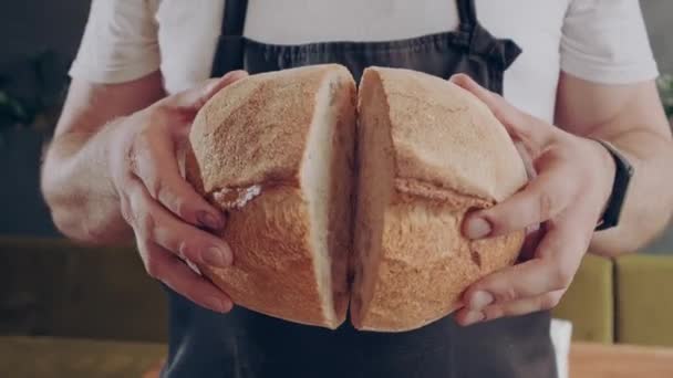 Vers mooi rond brood. Baker toont vers gebakken rond brood in gesneden. Close-up. - Video
