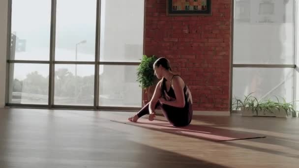 Kırmızı spor üniformalı genç bir kadın yoga stüdyosunda Astavakrasana Asana 'yı yapmaya çalışıyor. Denge egzersizi - Video, Çekim
