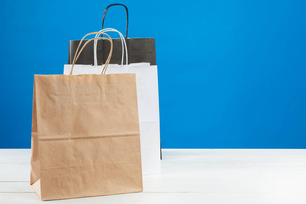 Arrangement of shopping bags on blue background - Foto, afbeelding