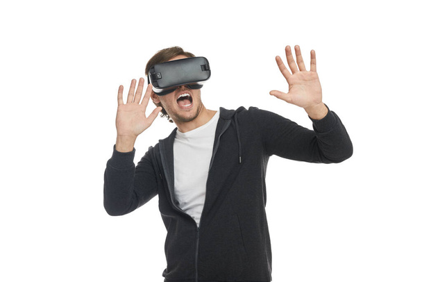 Scared man experiencing virtual reality in goggles - Foto, Bild