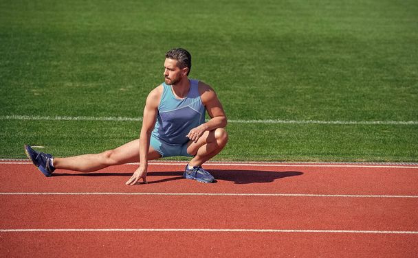 mature man stretching his legs before a stadium workout, stretch - 写真・画像