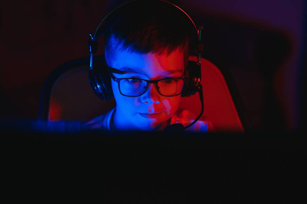 Boy in the headphones is playing a game. - Φωτογραφία, εικόνα