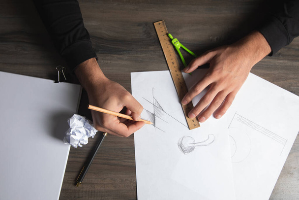 un uomo prende misure su carta con un righello e una matita - Foto, immagini