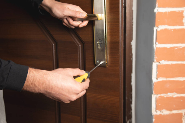 a man dismantles the door lock - Foto, Bild
